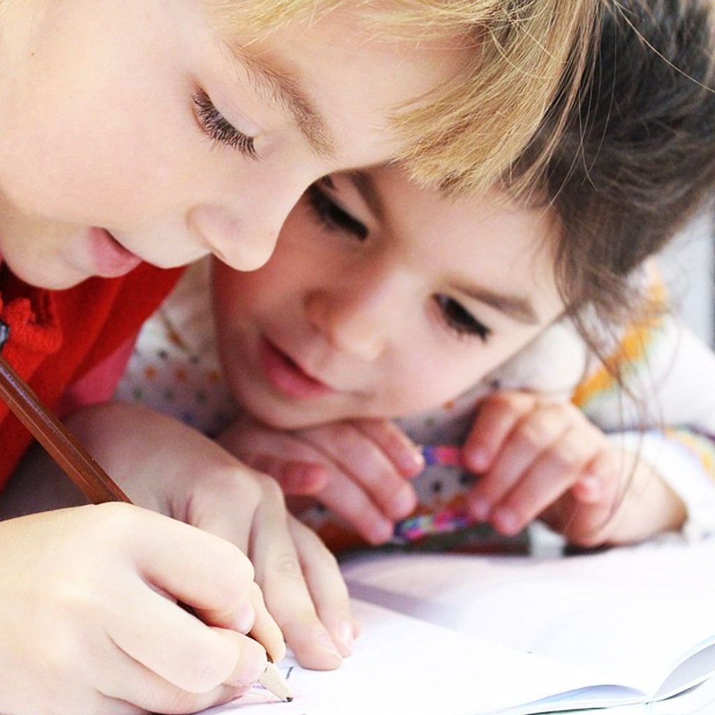 A girl writes in a notebook and her friend looks at her for Optimum UI design